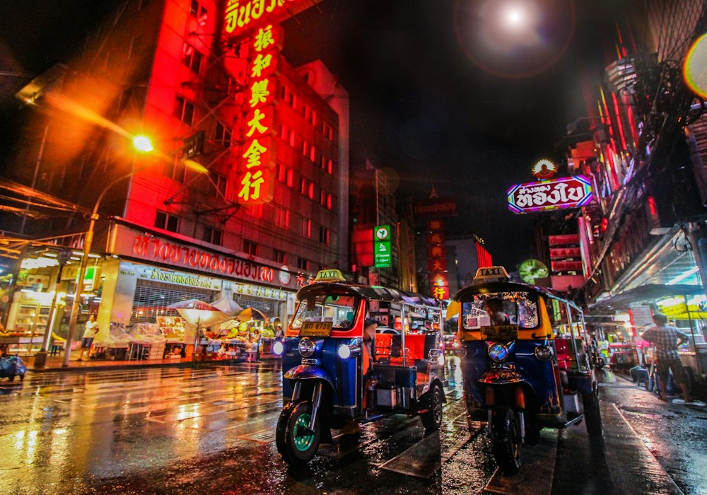 夜のバンコクの街並みを走るトゥクトゥク